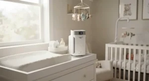 A sleek, compact air purifier placed on a nursery changing table to help clear secondhand smoke.