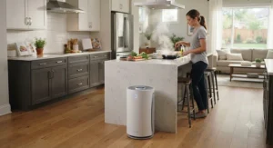 A sleek air purifier operating near a kitchen island during meal prep in an open floor plan home.